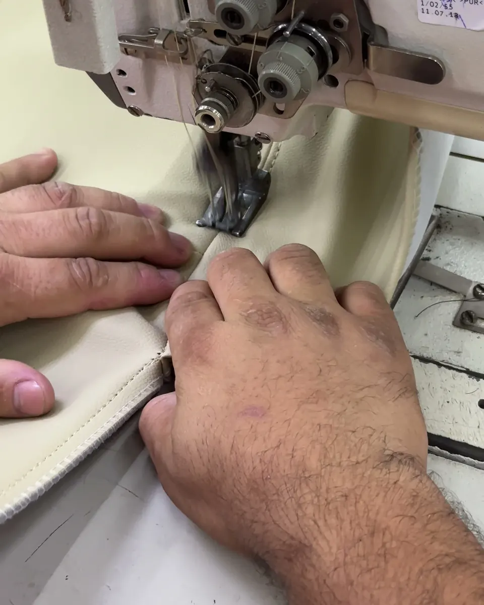 Mãos costurando na fábrica da Kairon